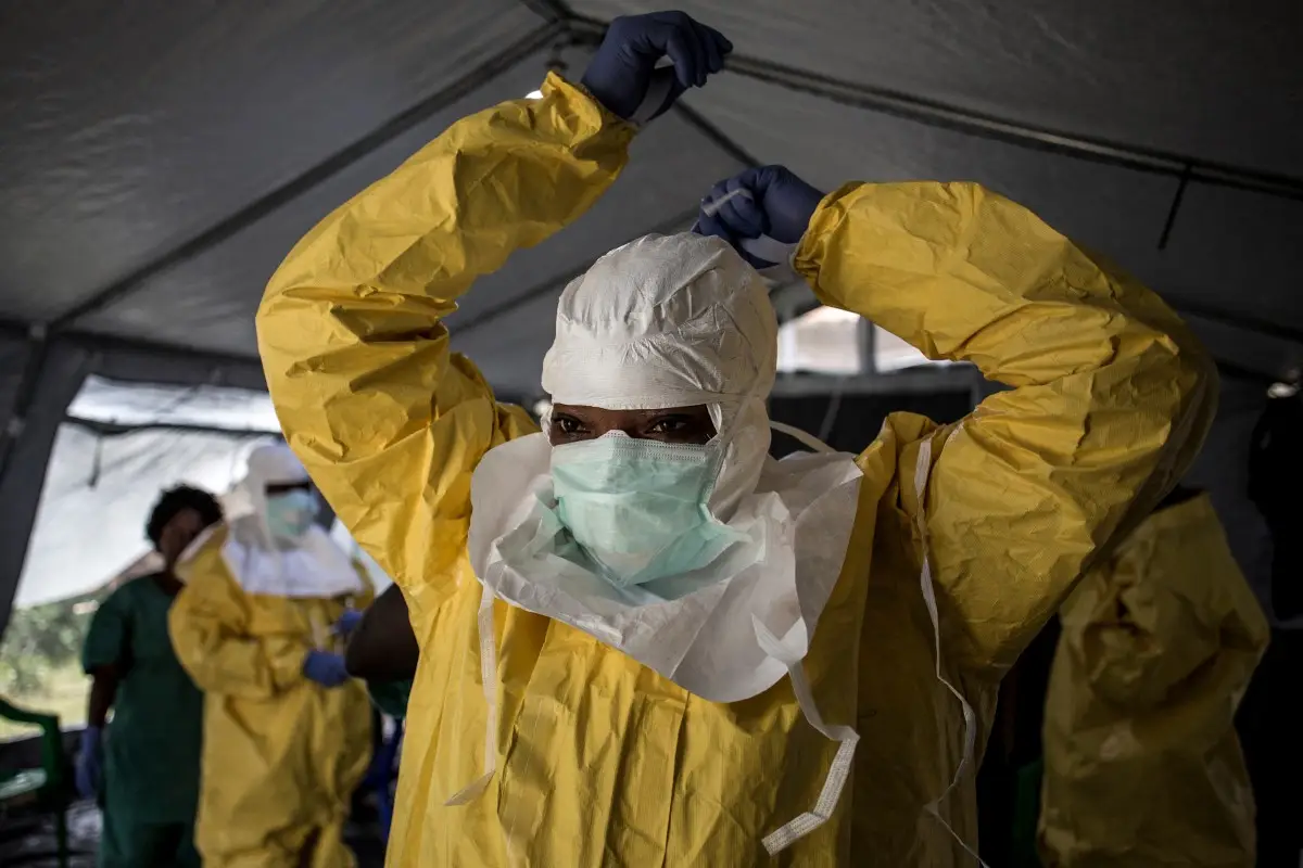 Una trabajadora médica se pone su Equipo de Protección Personal (EPP) antes de entrar en un Centro de Tratamiento del Ébola dirigido por la Alianza para la Acción Médica Internacional (ALIMA) el 12 de agosto de 2018, en Beni.