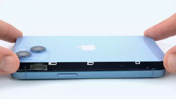 (Un empleado de la empresa de reparación de productos electrónicos iFixit quitando la parte posterior de un iPhone 14)