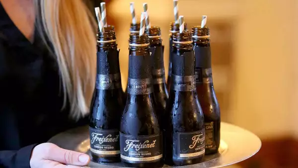 Freixenet México apuesta al turismo para vender vino (Botellas de Freixenet en una bandeja que sostiene una mesera)