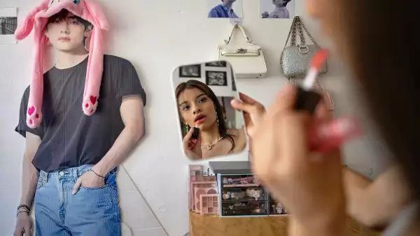 Ana Campos Rodríguez, una fan mexicana del grupo surcoreano de K-pop BTS, se maquilla junto a un recorte de cartón de la cantante de BTS Kim Tae-hyung, también conocida como V, en su casa de la Ciudad de México el 29 de abril de 2026.