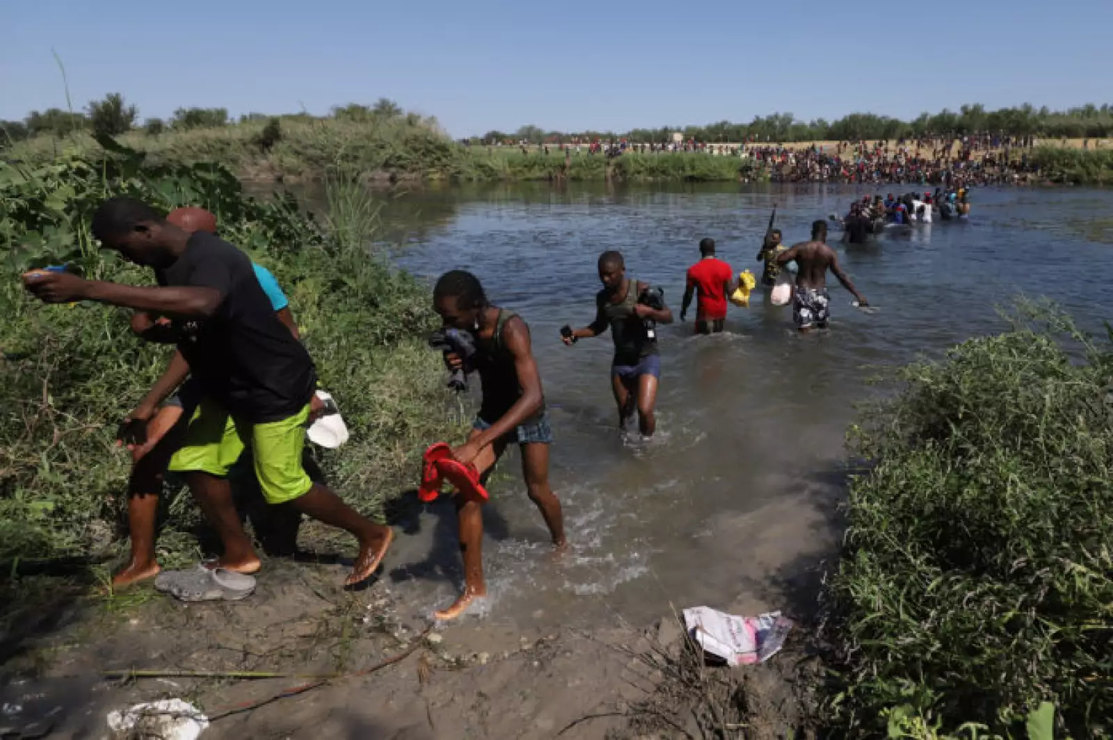 Haitianos cruzan el río Bravo del lado texano hacia suelo mexicano para conseguir comida y víveres. Los migrantes permanecen desde hace varios días en un campamento instalado de lado estadounidense en espera de que aquella nación les brinde asilo pol