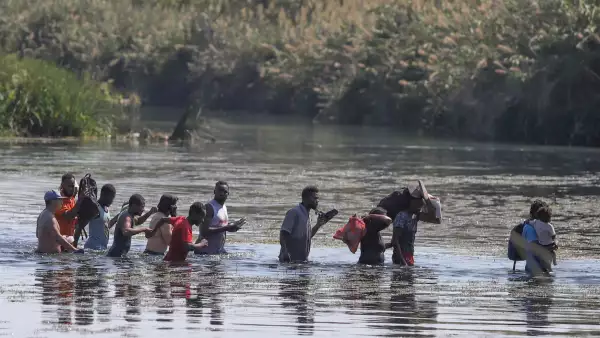 Haitianos cruzan el río Bravo del lado texano hacia suelo mexicano para conseguir comida y víveres. Los migrantes permanecen desde hace varios días en un campamento instalado de lado estadounidense en espera de que aquella nación les brinde asilo político.