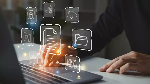 Businessman working on laptop with document management icon.