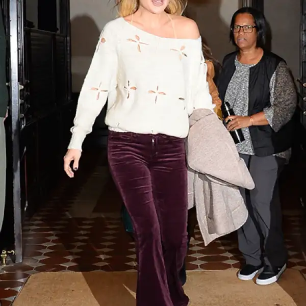 La actriz domina el look setentero con unos pantalones de terciopelo en color vino y un sueter con perforaciones en beige.