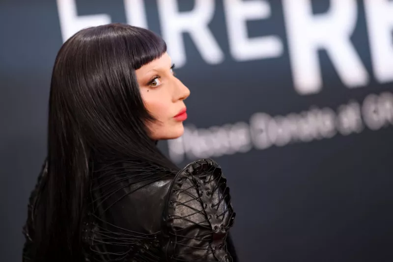 Foto de perfil de Lady Gaga con look gótico: cabello negro, fleco corto, labios rojos y ropa de cuero negra.