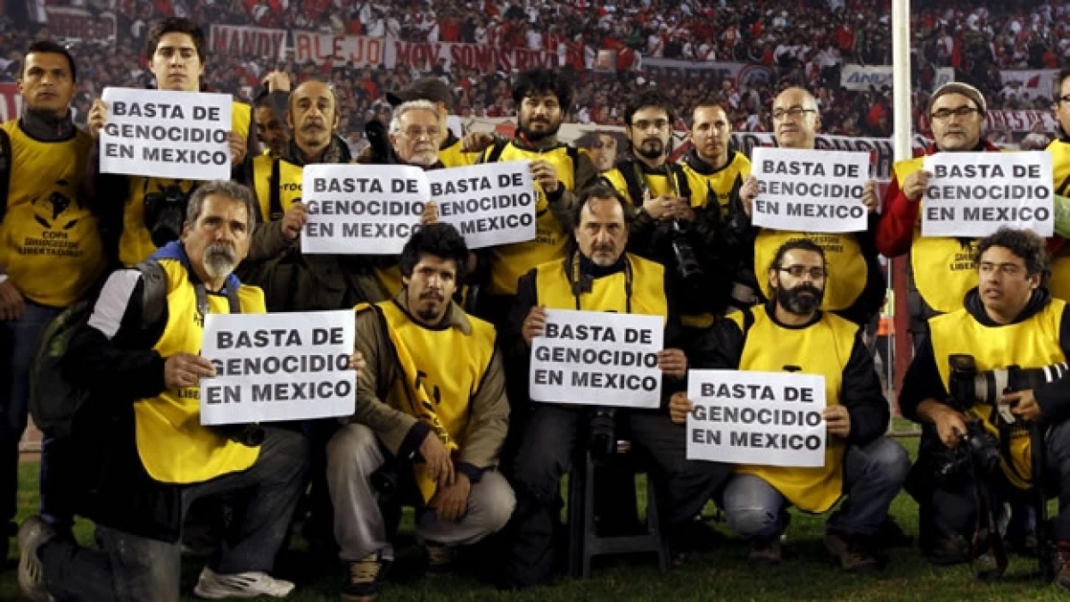 Los fotoperiodistas en la cancha del estadio Monumental con sus papeletas como protesta