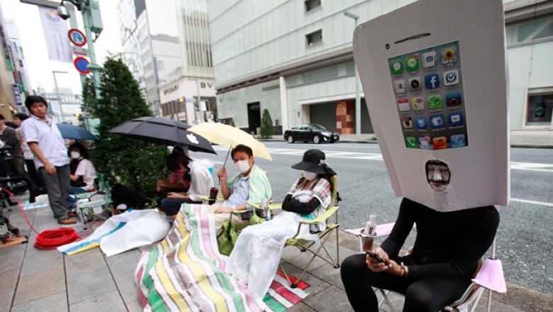 Los consumidores japoneses acamparon afuera de las tiendas y algunos se disfrazaron del porpular teléfono de Apple.
