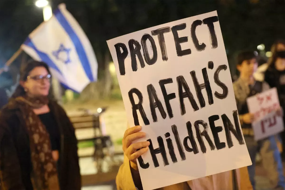 Los manifestantes se reúnen con carteles durante una protesta de activistas de izquierda israelíes contra la guerra en la Franja de Gaza y la operación terrestre planificada en Rafah, frente a la base militar de Kirya que alberga el Ministerio de Defensa en Tel Aviv el 13 de febrero de 2024 en medio del conflicto en curso. en Gaza entre Israel y el grupo militante palestino.