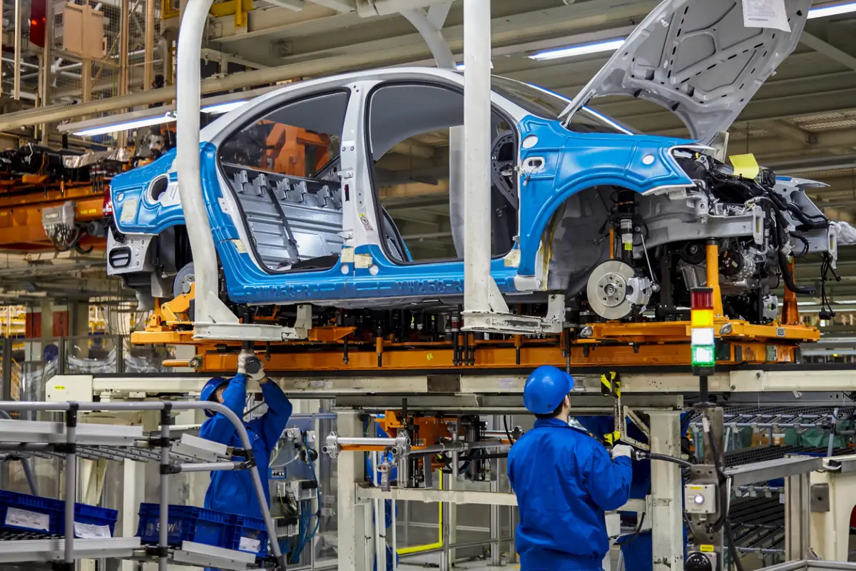 Workers are installing car chassis firmware on the production line of the Shanghai Volkswagen manufacturing workshop