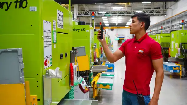 Trabajador de LEGO opera maquinaria en una planta de manufactura de la empresa en Nuevo León.