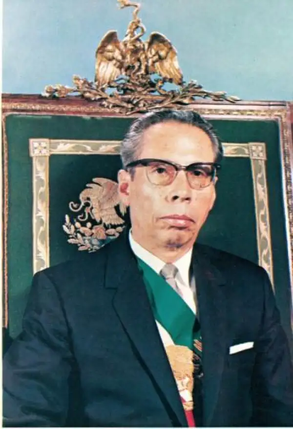 Gustavo Díaz Ordaz con la banda presidencial, lentes y sentado en la silla adornada con un águila y escudo nacional.jpeg