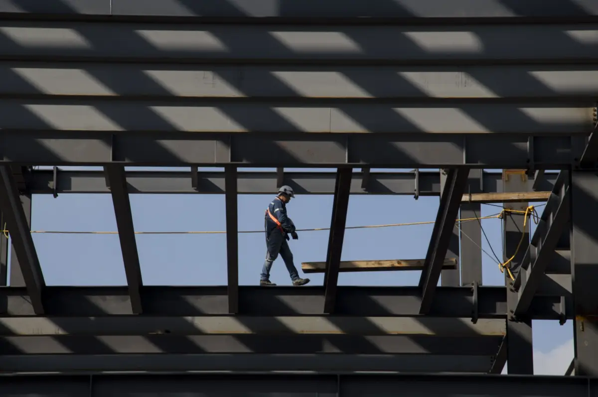 En la imagen, un trabajador camina por las trabes de la construcción de un edificio frente al Centro Cultural Universitario de Tlatelolco.