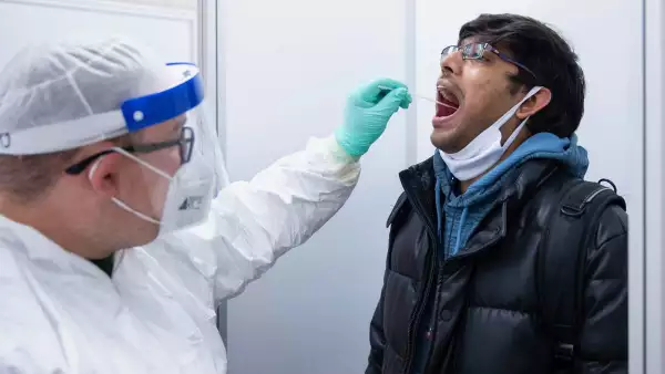 (Personal médico aplica de una prueba rápida de Covid-19 en la garganta)