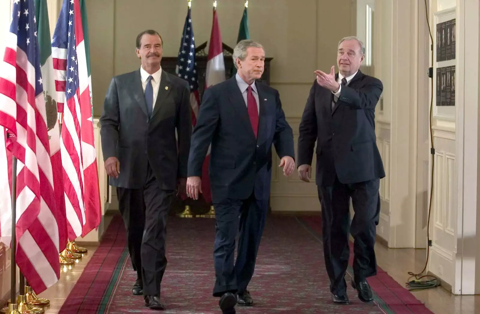 El presidente de México, Vicente Fox, el presidente de Estados Unidos, George W. Bush, y el primer ministro de Canadá, Paul Martin, caminan para dar una conferencia de prensa. 