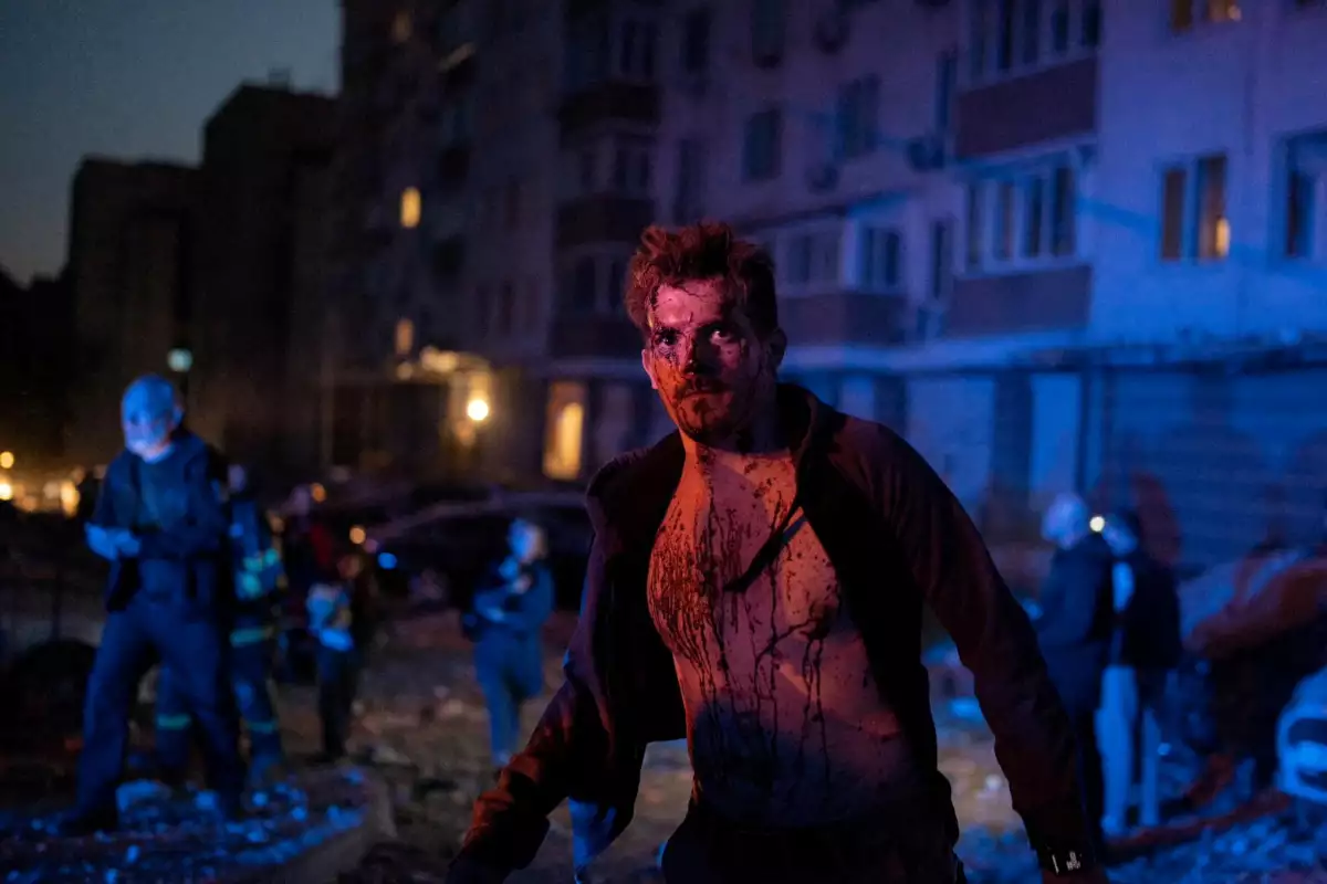 MATERIAL SENSIBLE. ESTA IMAGEN PUEDE OFENDER O PERTURBAR Un hombre herido se encuentra junto a un edificio de apartamentos que fue dañado durante un ataque masivo de aviones no tripulados rusos, en medio del ataque de Rusia contra Ucrania, en Kiev, Ucrania, el 30 de mayo de 2023.