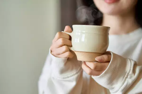 Asian woman relaxing with a drink.