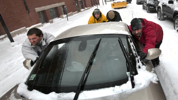 Millones de estadounidenses salieron temprano de sus trabajos por el temor a quedar varados en las carreteras. Un grupo de hombres en Portland ayuda a liberar un vehículo en la nieve.