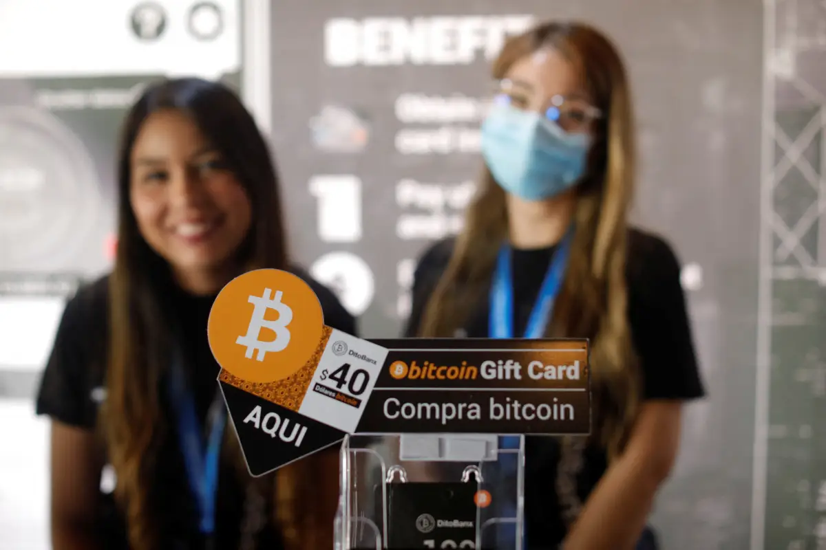 Promotoras esperan en un stand durante el lanzamiento de Adopting Bitcoin en San Salvador, El Salvador. 