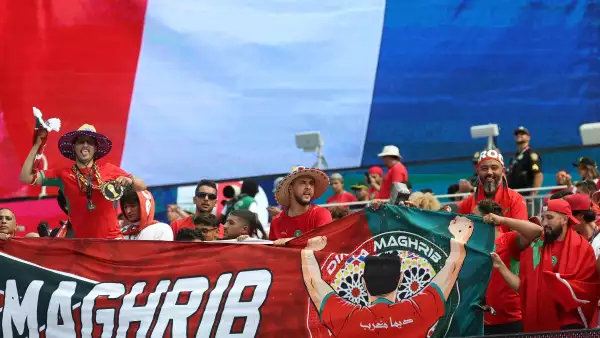 Los fanáticos marroquíes animan a su equipo con una bandera francesa en el fondo antes del partido de cuartos de final del torneo de la Copa Mundial de fútbol de 2026 entre Francia y Marruecos en el Estadio de Boston en Foxborough el 9 de julio de 2026.