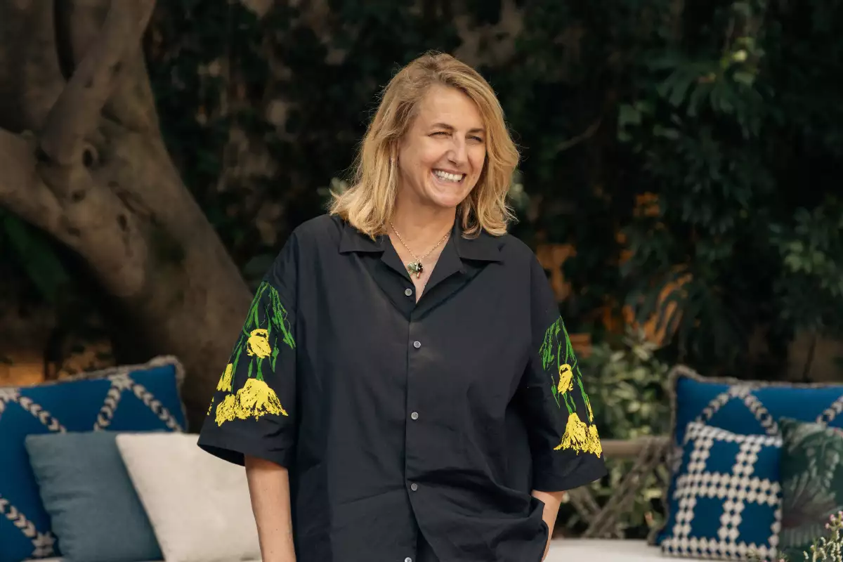 Foto de la arquitecta Patricia Urquiola con camisa over sized negra con mangas de flores amarillas.
