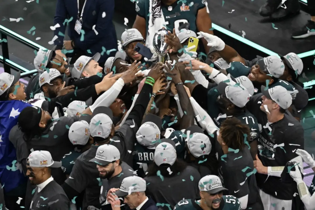 Foto del equipo Philadelphia Eagles tocando todos al mismo tiempo el trofeo Vince Lombardi.