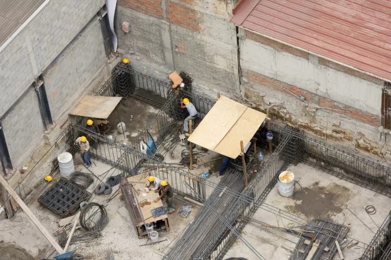 Vista área de una construcción en la Ciudad de México con alambrón y trabajadores