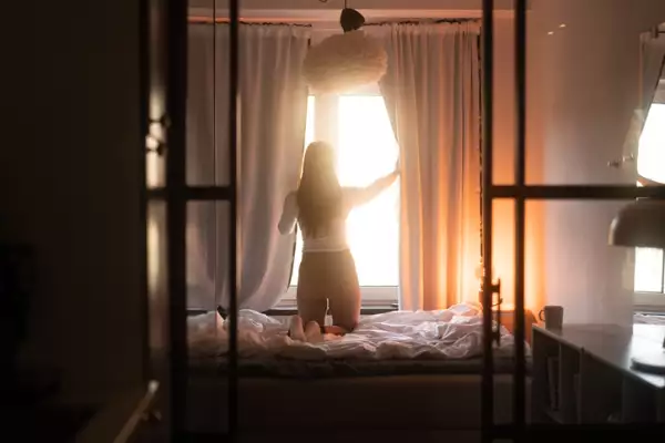 Opening up the curtain in the bedroom.