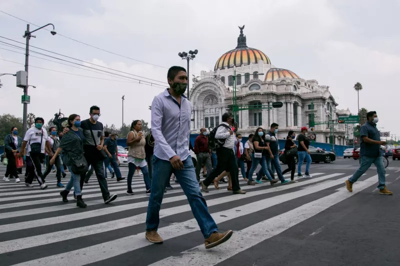 Decenas de personas cruzan hacia la calle de Madero en el Centro Histórico durante el semáforo naranja por Covid-19.