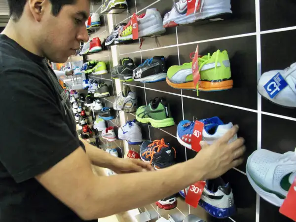 Consumidor revisa tenis en descuento.