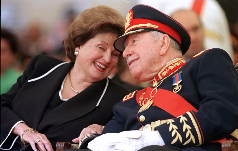En esta foto, tomada el 10 de marzo de 1998, el ex dictador de Chile, el general Augusto Pinochet, escucha a su esposa Lucia Hiriart durante su ceremonia de retiro del ejército chileno. 