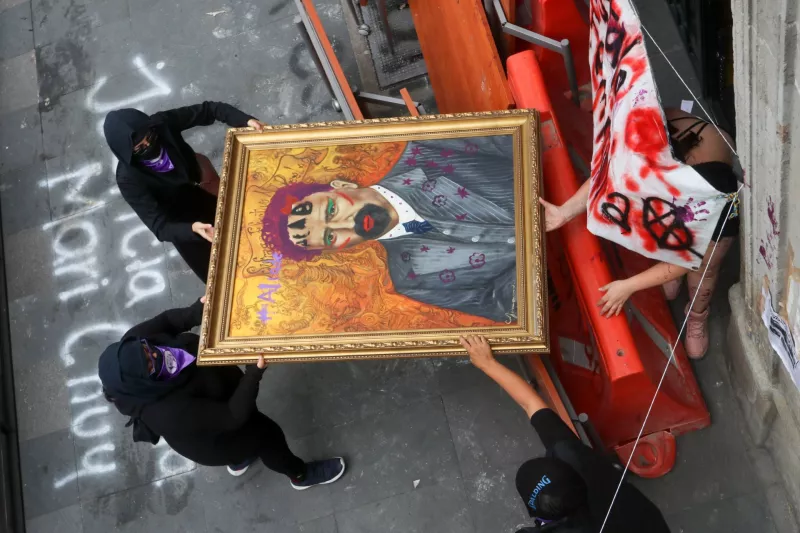 Colectivas de feministas cargaron uno de los cuadros intervenidos durante el tercer día de la toma de las instalaciones