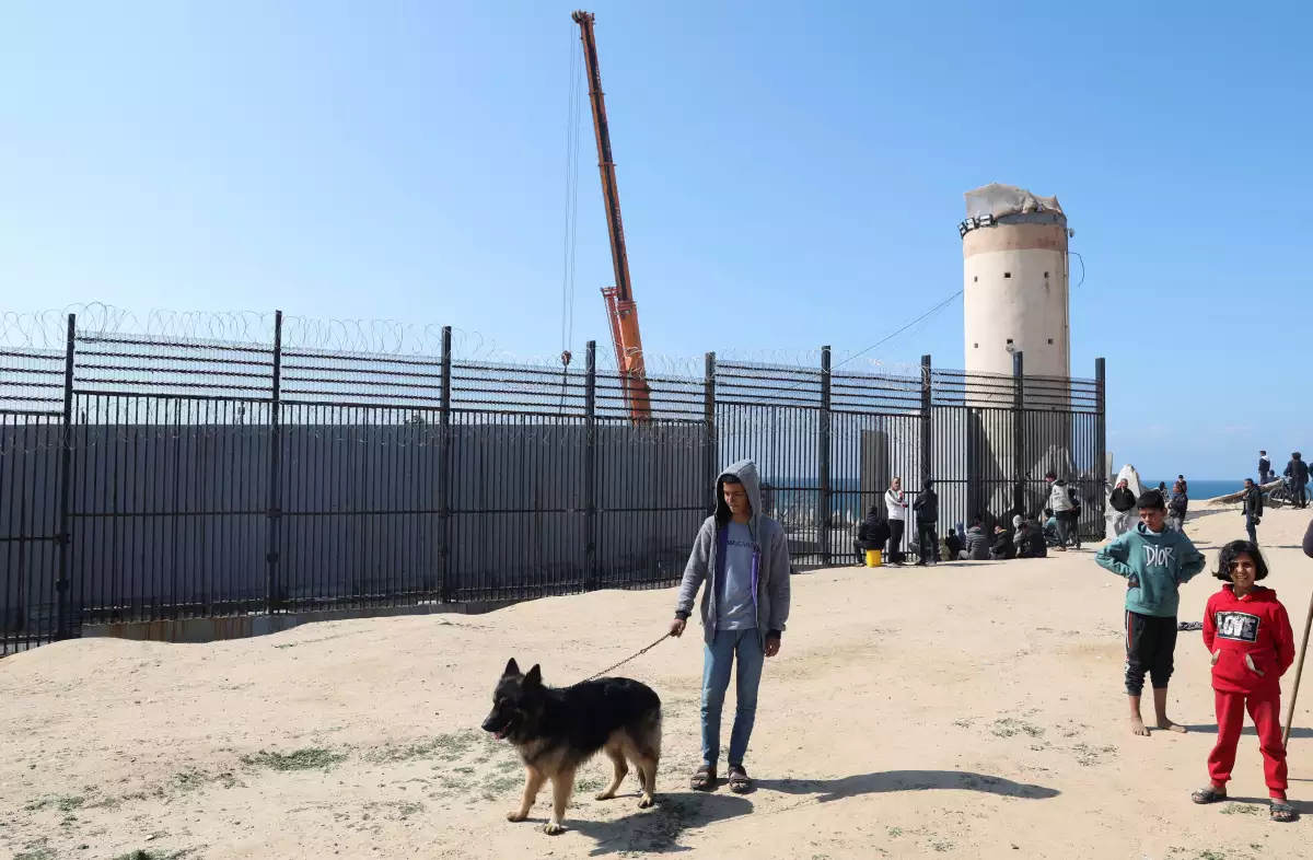 El adolescente palestino desplazado Hassan Abu Saman sostiene a su perro mientras lo pasea en la frontera con Egipto, en medio del conflicto en curso entre Israel y el grupo islamista palestino Hamas, en Rafah, en el sur de la Franja de Gaza, el 20 de febrero de 2024.