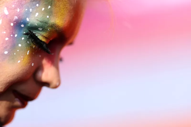 (Un asistente a la marcha del orgullo LGBT, muestra un maquillaje con los colores del arcoíris​​)