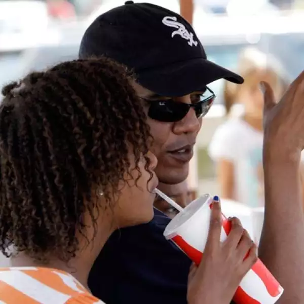 El presidente Barack Obama, usando una gorra de los Chicago White Sox, acompañado de su hija Malia.