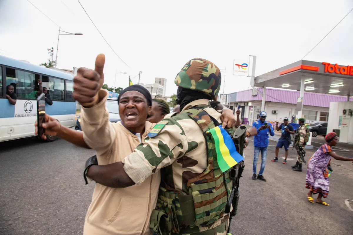 Una mujer abraza a un soldado mientras celebra con gente en apoyo de un golpista, en una calle de Port-Gentil, Gabón, 30 de agosto de 2023.