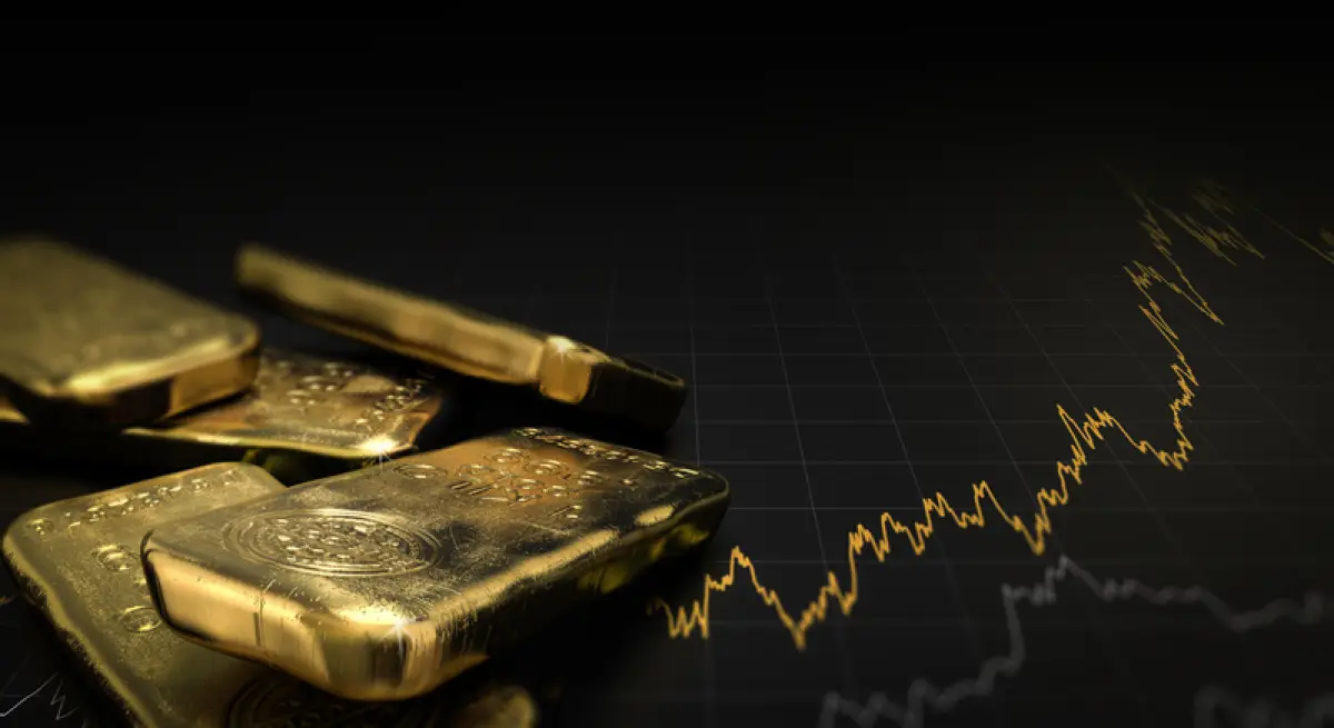 Lingotes de oro con una gráfica de su precio.