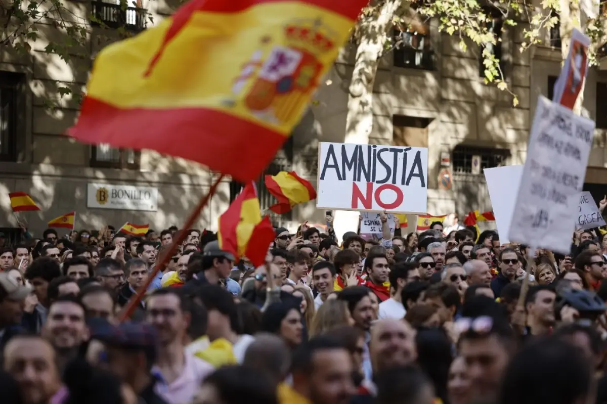 Un manifestante sostiene un cartel que dice "Amnistía no" durante una protesta convocada por la oposición de derecha contra un proyecto de ley de amnistía para las personas involucradas en la fallida candidatura de independencia de Cataluña en 2017, frente a la sede del PSOE (Partido Socialista de España) en Madrid el 12 de noviembre de 2023.