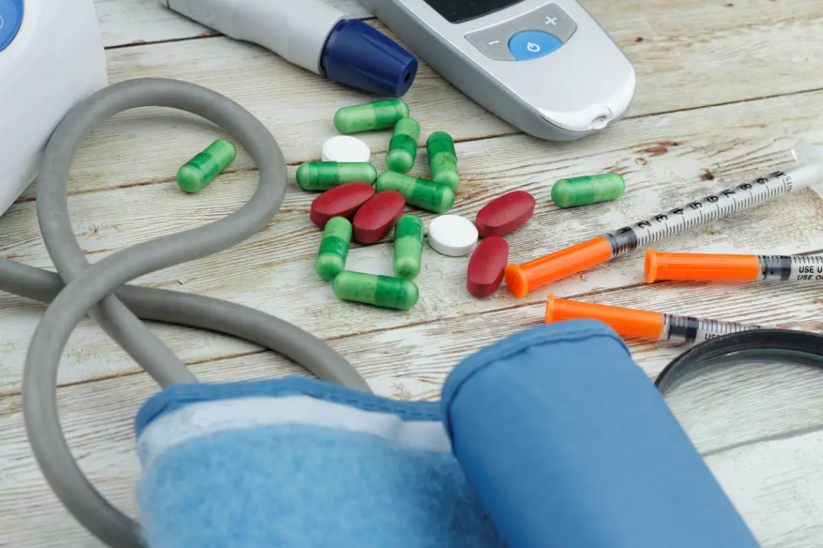 Healthcare concept with medicine and syringes on the table together with blood glucose monitor and blood pressure monitor