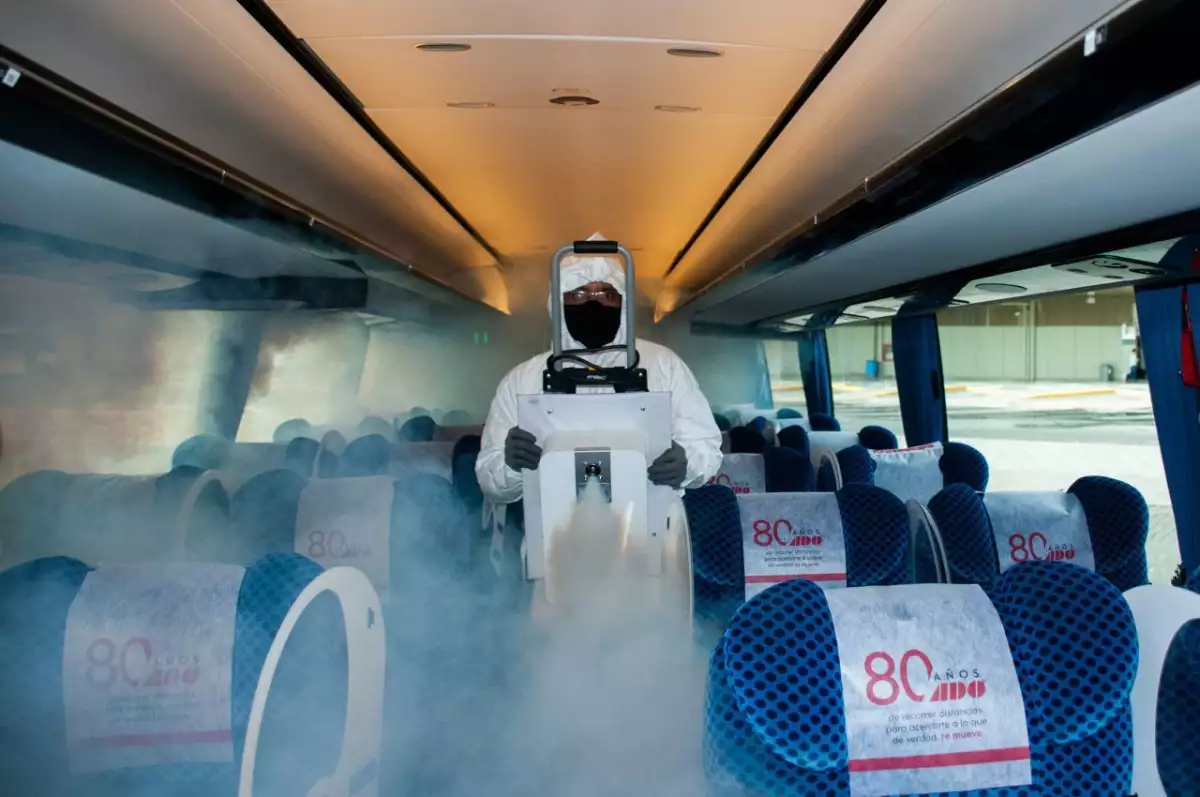 Un trabajador de la TAPO sanitiza un autobús de pasajeros.