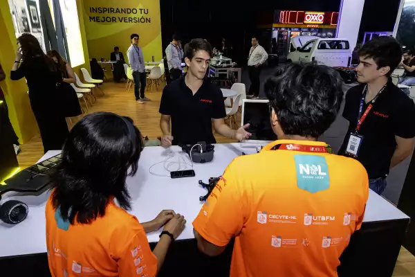 Foto de estudiantes de la UDEM en el stand presentando los proyectos como los drones autónomos, un exoesqueleto robótico y un vehículo de hidrógeno.