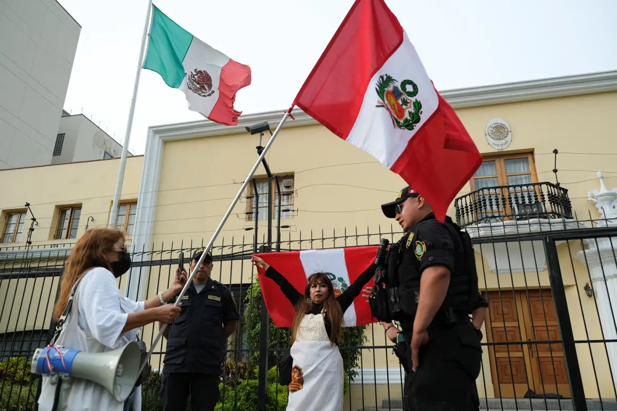 Los manifestantes se paran fuera de la embajada mexicana después de que el ministro de Relaciones Exteriores de México, Marcelo Ebrard, dijera que México ha concedido asilo a la familia del expresidente peruano Pedro Castillo, en Lima, Perú, el 20 de diciembre de 2022.