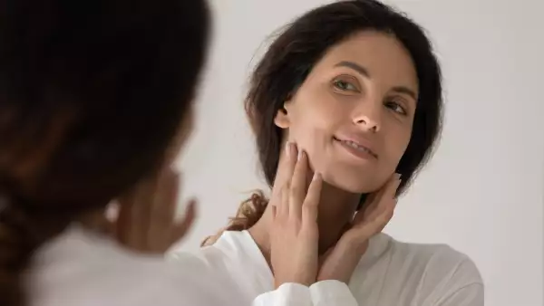 Close,Up,Happy,Beautiful,Woman,Touching,Face,,Looking,In,Mirror,