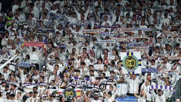 Foto de los aficionados del Real Madrid en las gradas apoyando a su equipo.