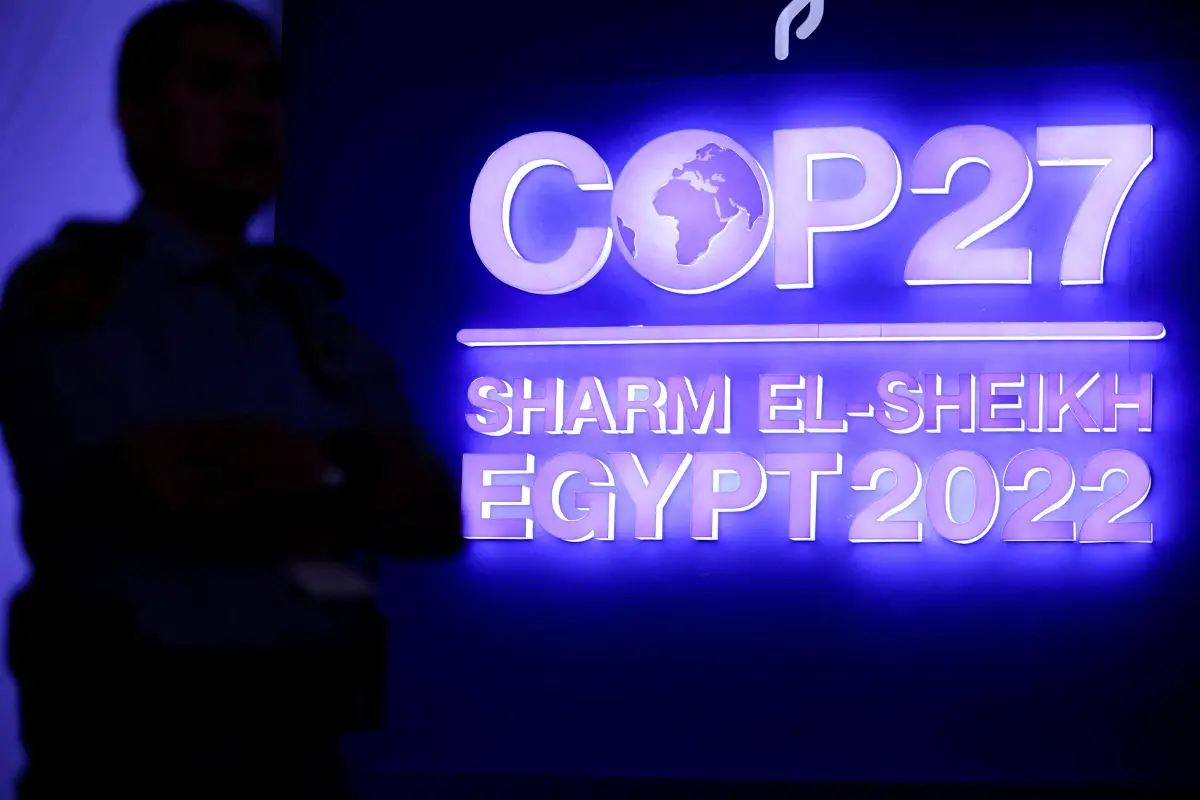 Un guardia de seguridad se para junto al logo de la COP27 durante la sesión plenaria de clausura. 