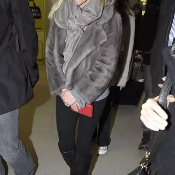 Reese Witherspoon lució un foulard y abrigo del mismo color, contrastándolo con jeans y botas negras. Aquí durante su llegada a Berlín, Alemania.