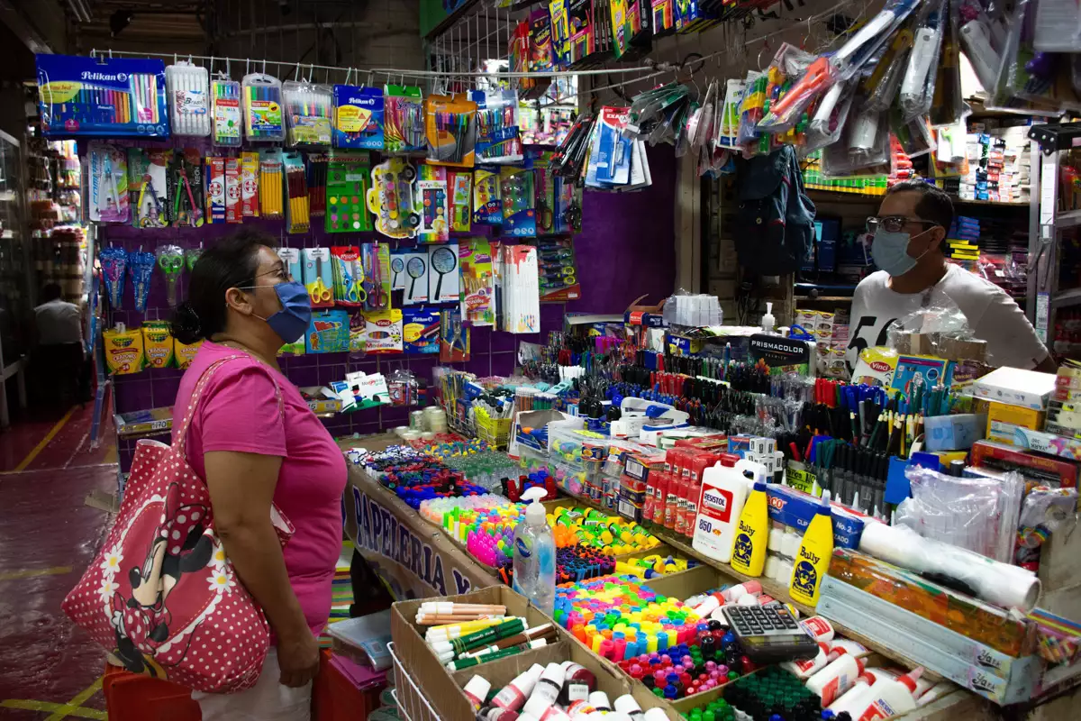 (Mujer comprando útiles escolares en una papelería)