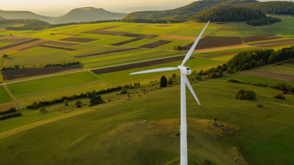 Alternative Energy Wind Turbine in Beautiful Green Landscape at Sunset
