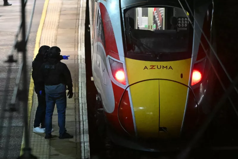 Los agentes de policía trabajan en la plataforma junto a un tren LNER Azuma en la estación de Huntingdon en Huntingdon, al este de Inglaterra, el 1 de noviembre de 2025, después de un apuñalamiento en un tren.
