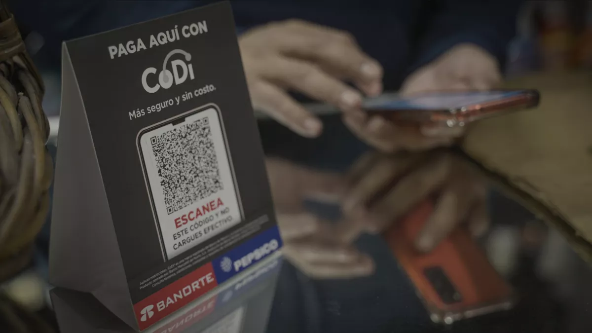 Se muestra el código QR de Codi mientras una persona está realizando el pago en una tiendita al comprar productos de Pepsico.