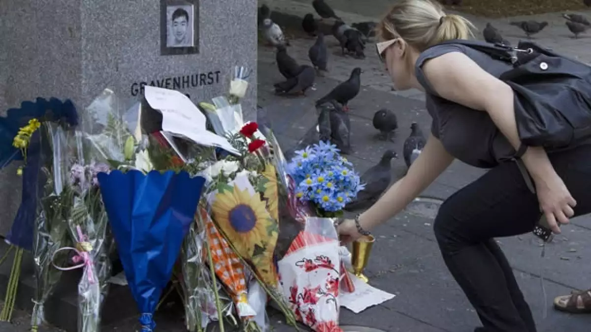 una mujer deja flores en un monumento de la universidad concordia